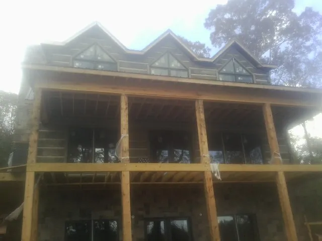 Dormers and porch framing on a large log home under construction — Roof Coating work by our crew in Darwin