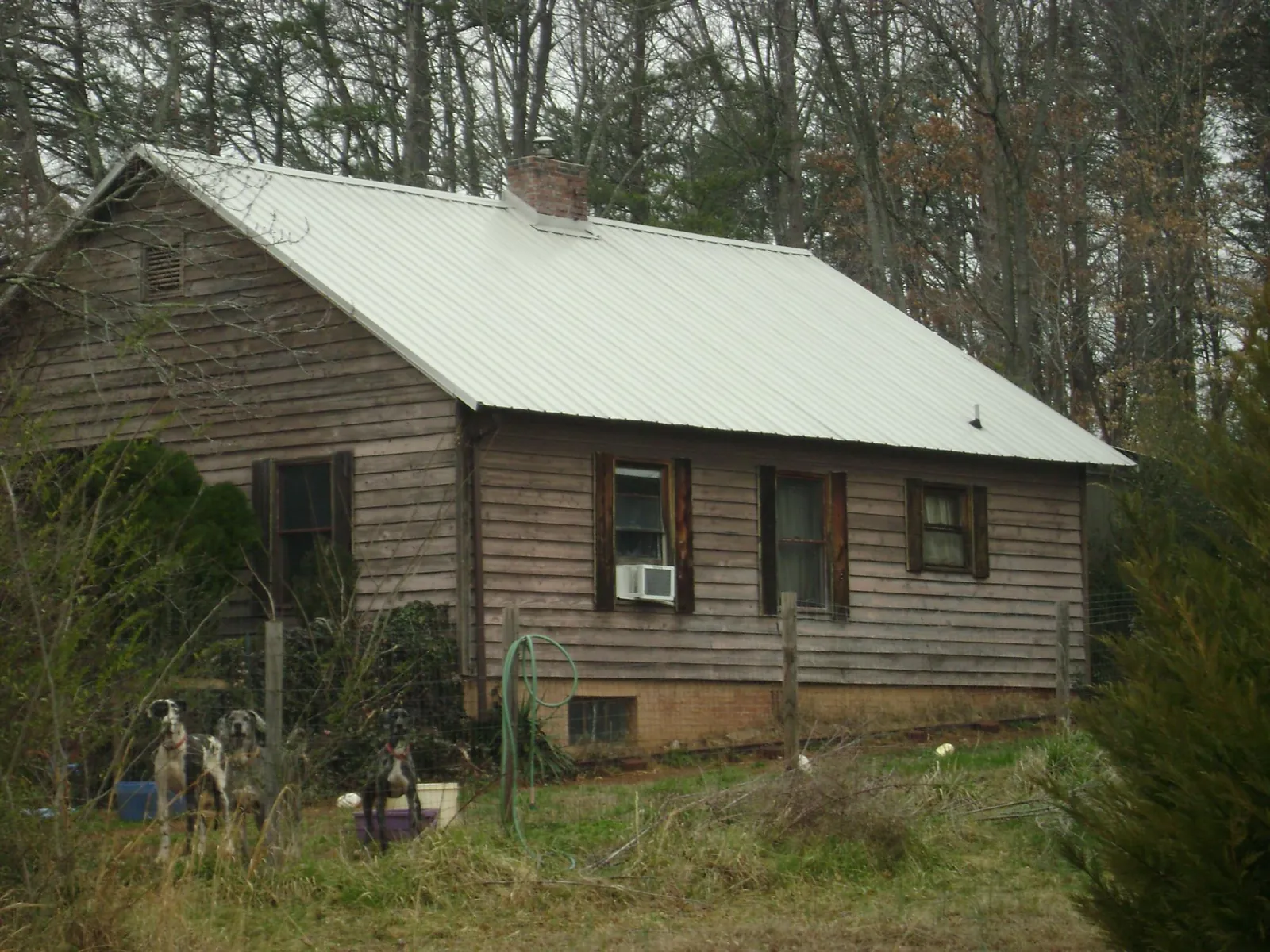 White metal roof on an old wood sided farmhouse, from a Asphalt Shingle Roof Repair job in Darwin